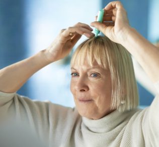 Woman putting on hair glue